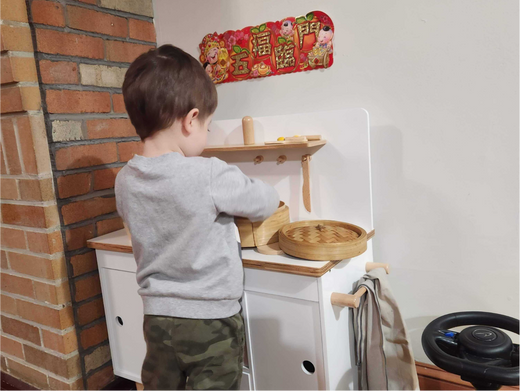 Little Boy Playing at Play Kitchen