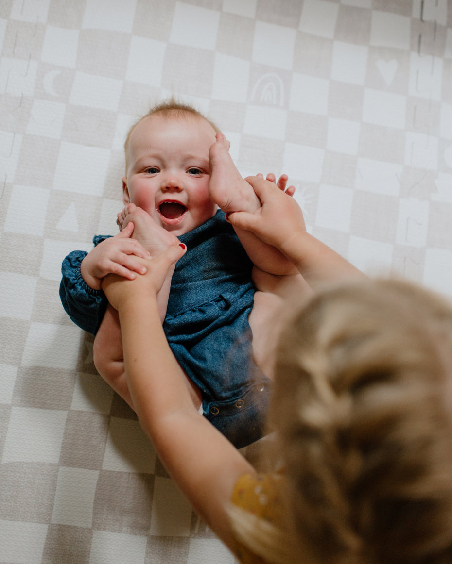 Baby and little girl playing on the Play Mat in Oatmeal Checkered