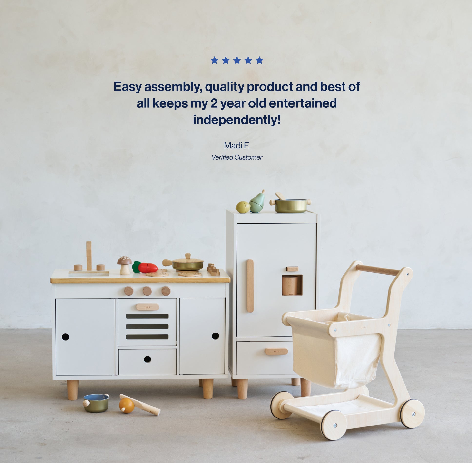 5 Star Review saying Easy assembly, quality product and best of all keeps my 2 year old entertained independently by Madi F, verified customer with the Play Kitchen, Play Fridge and Shopping cart in the background